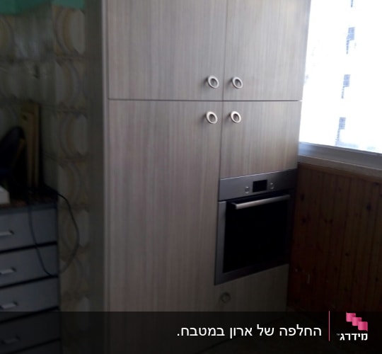 ארון עץ עם ידיות עגולות ותנור מובנה